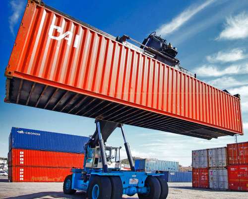 Maquinaria pesada descargando contenedores